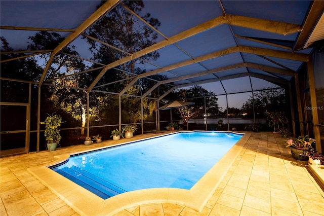 pool featuring glass enclosure and a patio