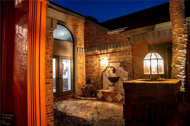 exterior space featuring french doors and brick siding