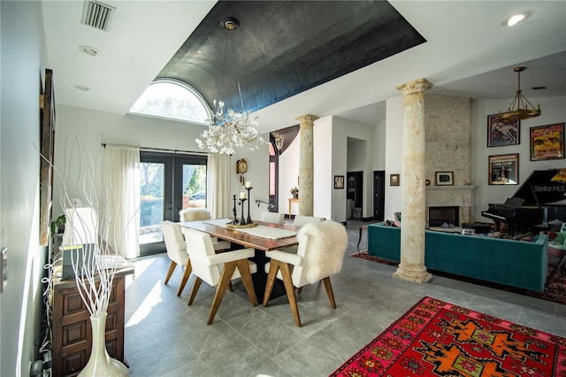tiled dining room featuring ornate columns, an inviting chandelier, visible vents, french doors, and a large fireplace