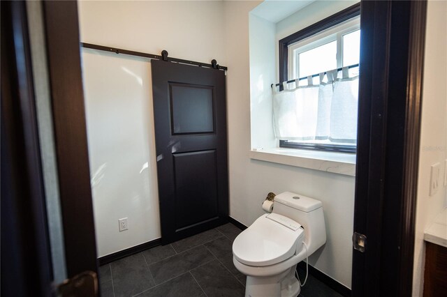 half bath featuring baseboards, tile patterned flooring, and toilet