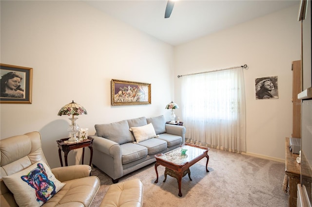 living area featuring a ceiling fan, baseboards, and carpet