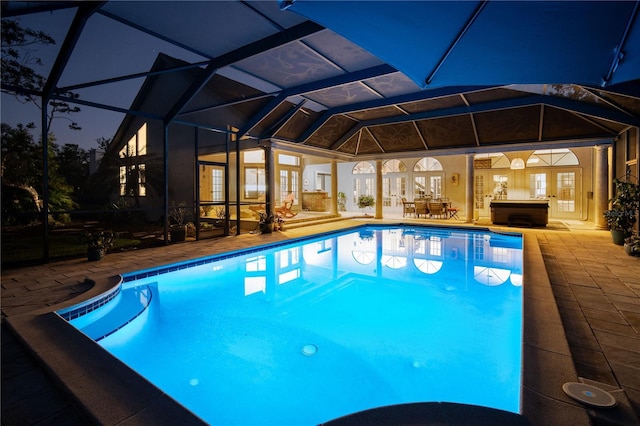 outdoor pool featuring glass enclosure, a patio, and french doors