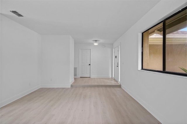 unfurnished room with baseboards, visible vents, and light wood-style floors