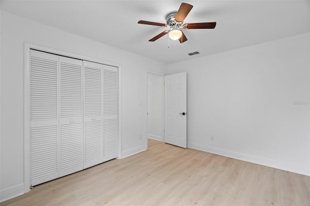 unfurnished bedroom with a closet, light wood-type flooring, visible vents, and baseboards