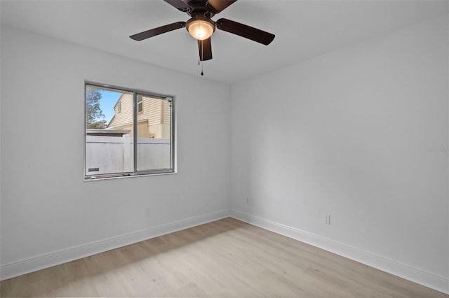 spare room with light wood-style floors, baseboards, and a ceiling fan