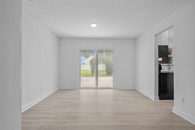 unfurnished living room with light wood-style flooring and baseboards