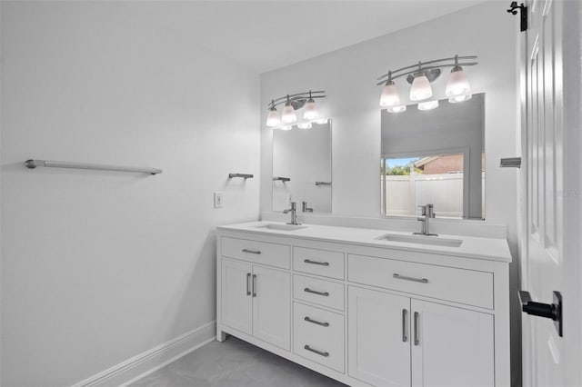 full bathroom featuring double vanity, a sink, and baseboards