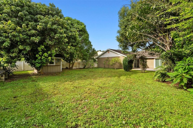 view of yard featuring a fenced backyard and a shed