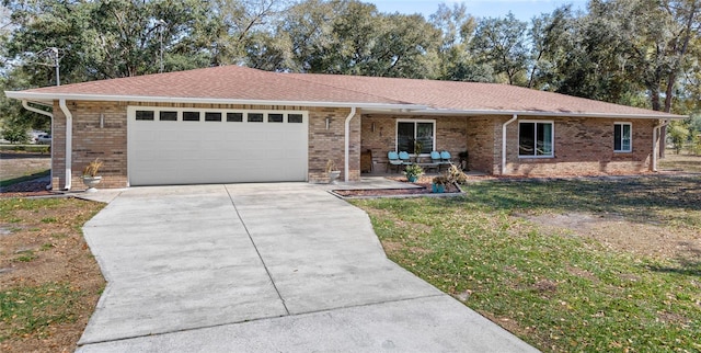 ranch-style home featuring brick siding, roof with shingles, concrete driveway, a front yard, and a garage