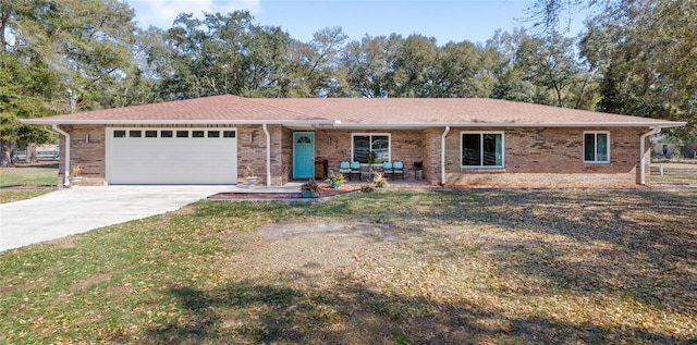 single story home featuring a porch, a garage, brick siding, concrete driveway, and a front yard