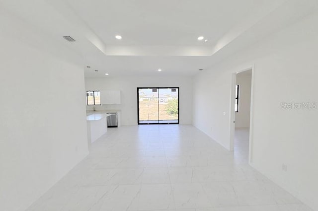 unfurnished room with recessed lighting, a raised ceiling, and visible vents