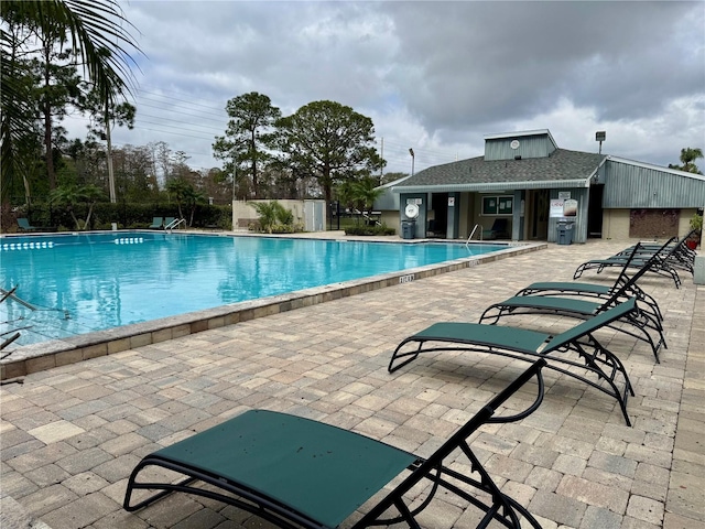 pool with a patio area and fence