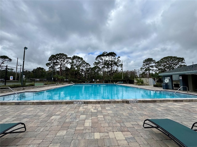 community pool featuring a patio area and fence