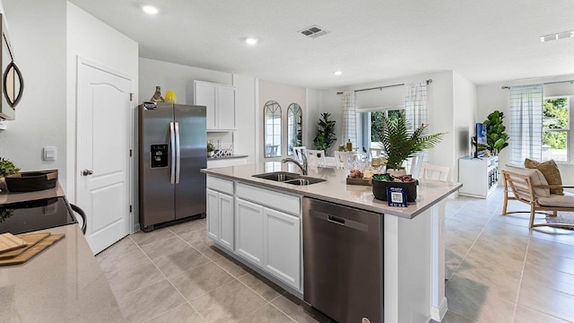 kitchen with a center island with sink, visible vents, appliances with stainless steel finishes, white cabinets, and a sink