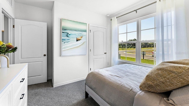 bedroom with baseboards, visible vents, and dark carpet