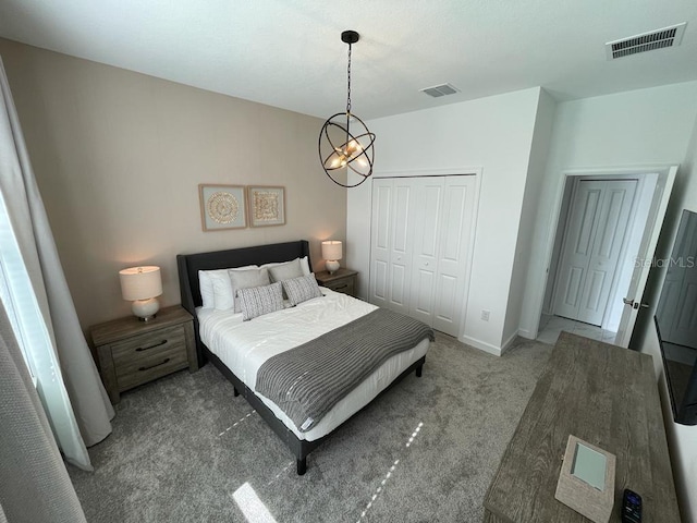 bedroom featuring a closet, carpet flooring, visible vents, and baseboards