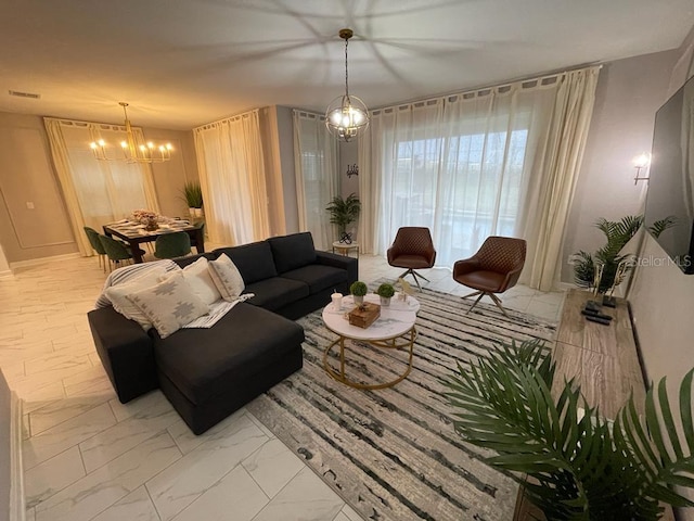 living room with an inviting chandelier, visible vents, and marble finish floor