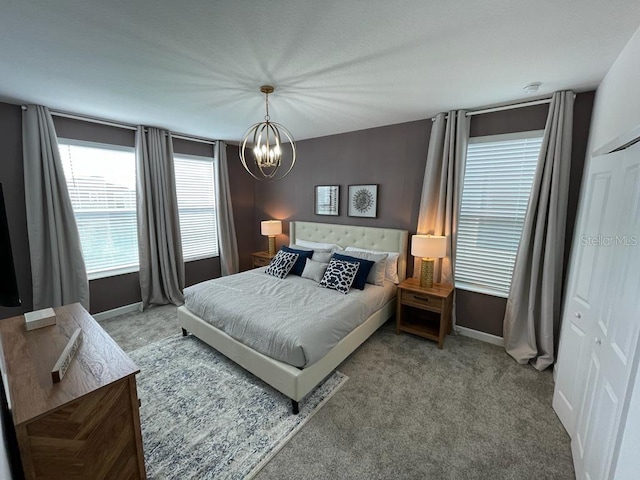 bedroom with carpet, an inviting chandelier, and baseboards