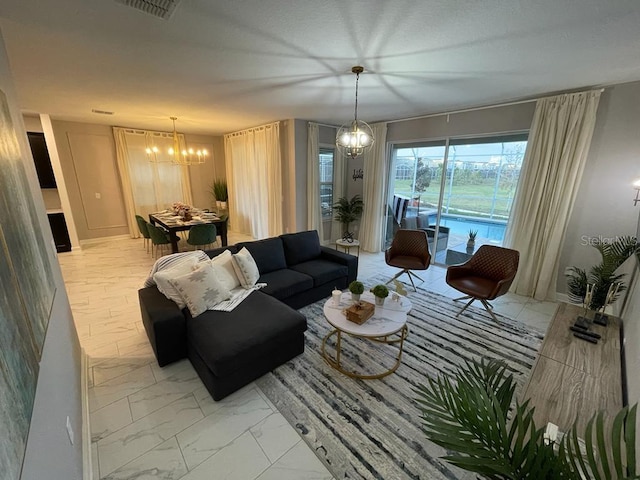 living room with marble finish floor, visible vents, and a chandelier