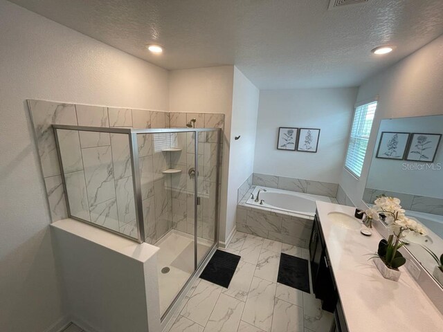 full bathroom featuring marble finish floor, vanity, a shower stall, a textured ceiling, and a bath