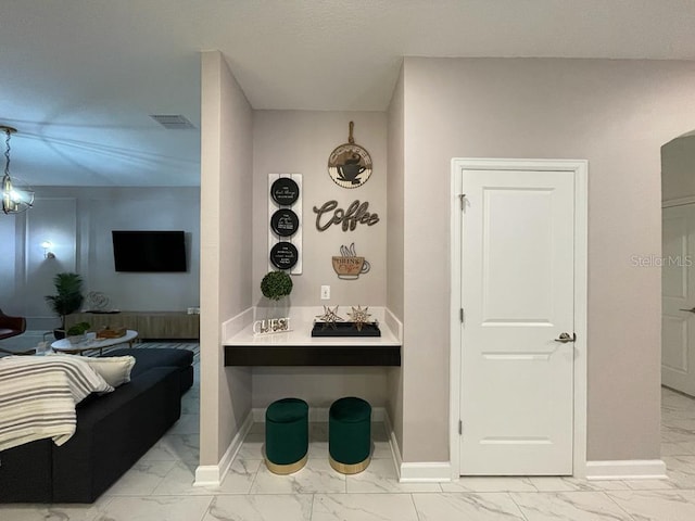 hall featuring marble finish floor, baseboards, visible vents, and arched walkways