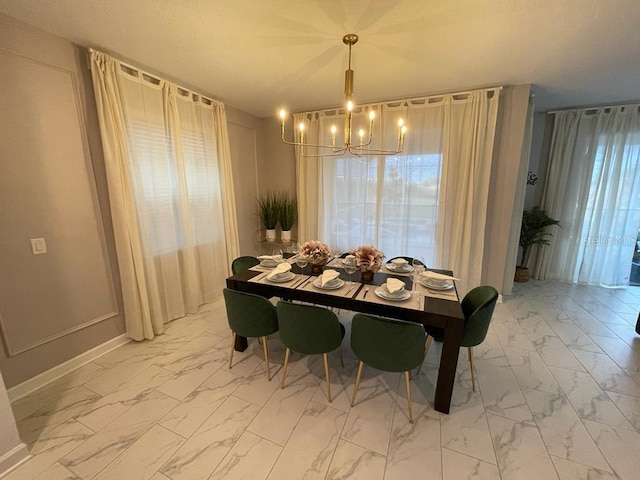 dining space featuring baseboards, marble finish floor, and a notable chandelier