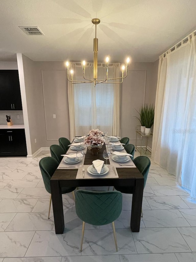 dining space with marble finish floor, an inviting chandelier, visible vents, and baseboards