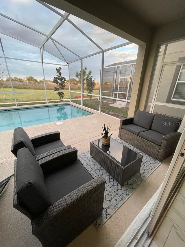 pool featuring glass enclosure, a patio area, and an outdoor living space