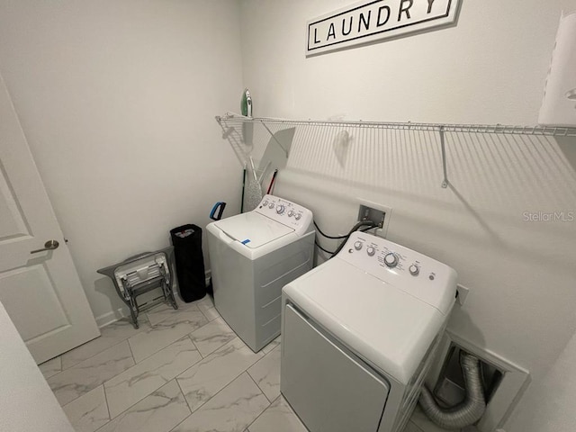 laundry room featuring marble finish floor, separate washer and dryer, and laundry area