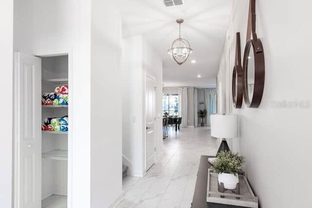 hallway featuring marble finish floor, a notable chandelier, recessed lighting, visible vents, and stairway