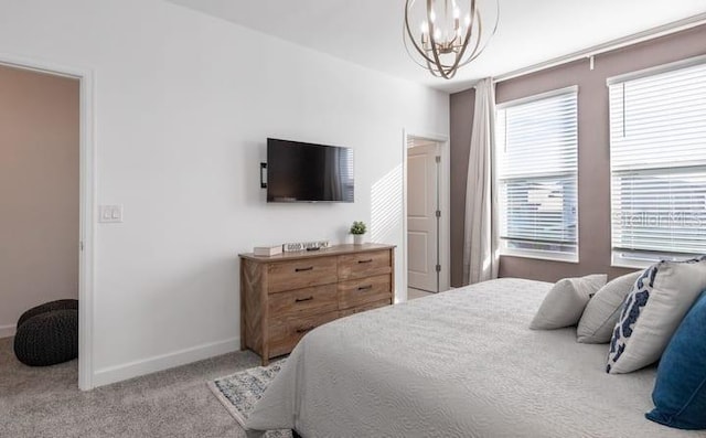 bedroom with a chandelier, light carpet, and baseboards