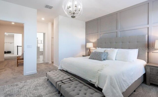 bedroom featuring visible vents, light colored carpet, a chandelier, a decorative wall, and recessed lighting