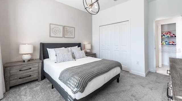 bedroom with an inviting chandelier, baseboards, a closet, and light colored carpet