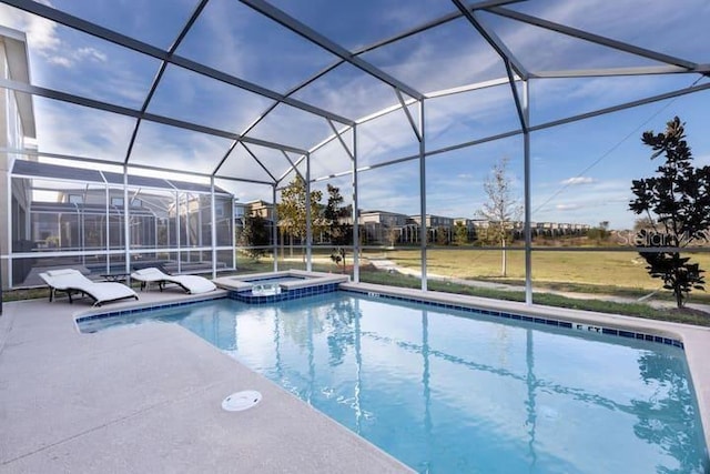 view of pool with glass enclosure, a pool with connected hot tub, and a patio area