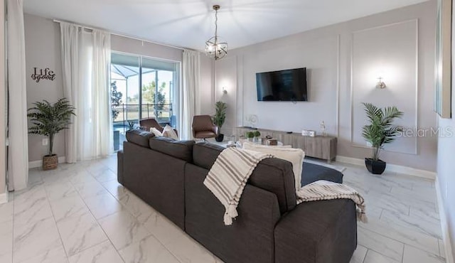 living room with marble finish floor, baseboards, and a chandelier