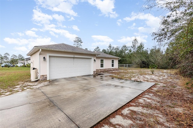 exterior space with a garage, driveway, and stucco siding