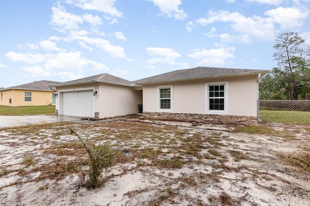 view of front of property with a garage, fence, driveway, and stucco siding