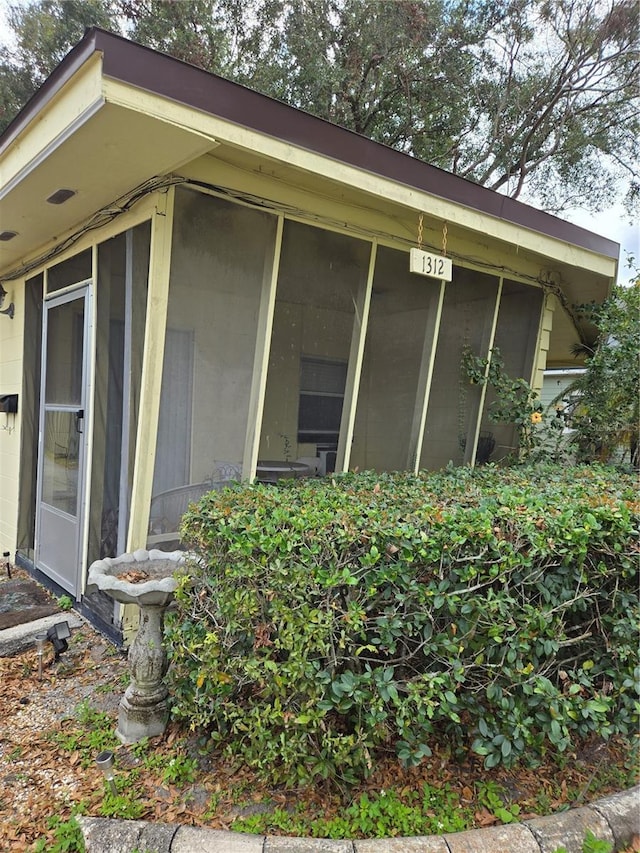 view of property exterior with a sunroom