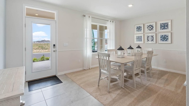 dining room with recessed lighting, light carpet, baseboards, and light tile patterned floors