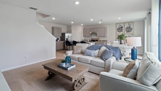 living room featuring recessed lighting, visible vents, light carpet, and baseboards