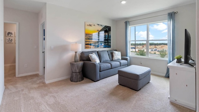 living area featuring baseboards and light colored carpet