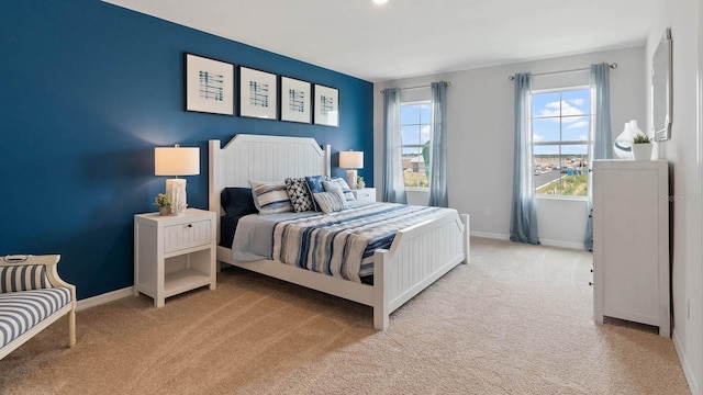 bedroom with baseboards and light colored carpet