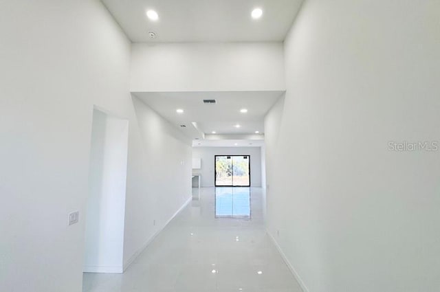 hall featuring visible vents, baseboards, and recessed lighting