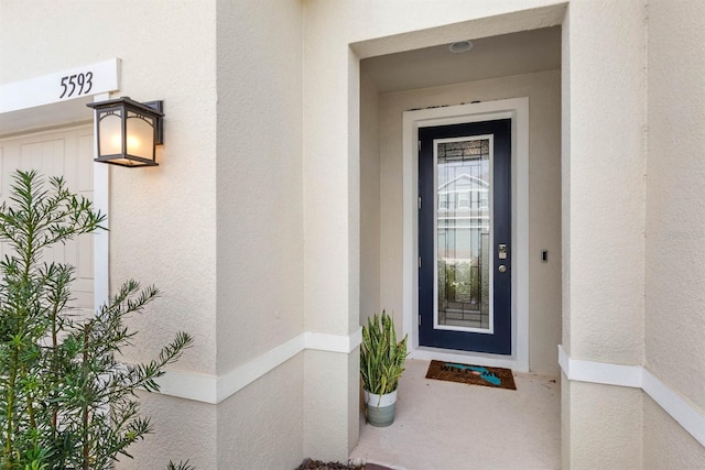 doorway to property featuring stucco siding