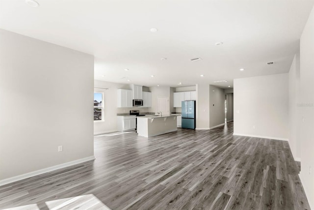 unfurnished living room featuring recessed lighting, light wood-style flooring, and baseboards