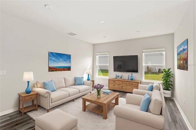 living area featuring wood finished floors, visible vents, and baseboards