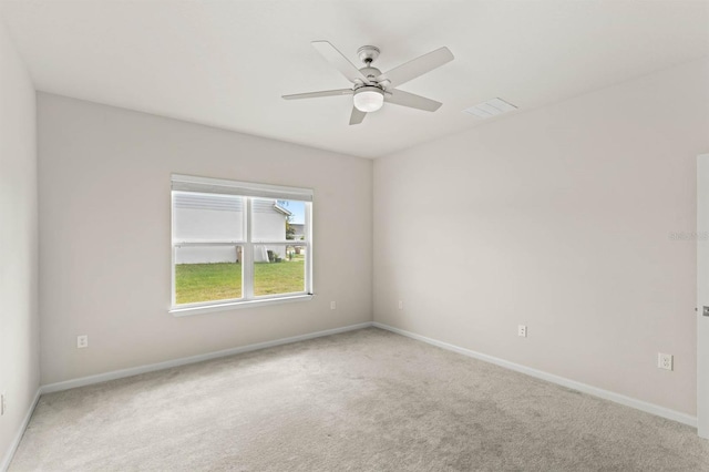 carpeted empty room with ceiling fan, visible vents, and baseboards