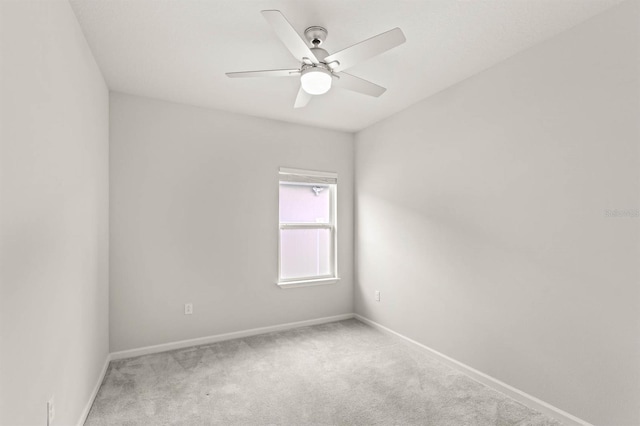 empty room featuring ceiling fan, carpet floors, and baseboards