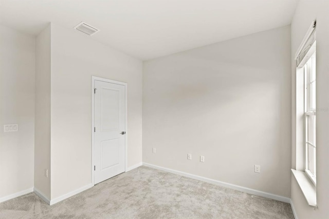 unfurnished room with light carpet, baseboards, visible vents, and a healthy amount of sunlight