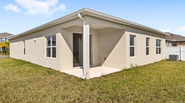 view of home's exterior with a yard, central AC unit, and stucco siding